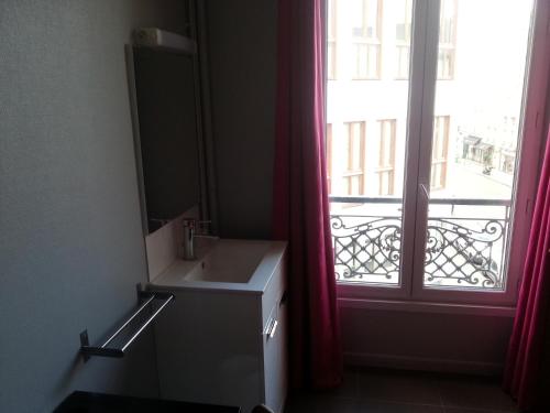 uma casa de banho com um lavatório e uma janela em Hipotel Paris Bastille Saint Antoine em Paris
