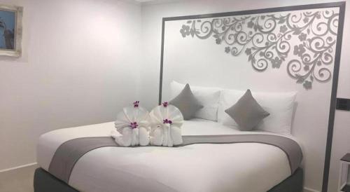 a white bed with two white towels on it at white house in Phangnga