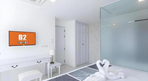 ein weißes Bad mit einer Uhr an der Wand in der Unterkunft B2 Hua Hin Premier Hotel in Hua Hin