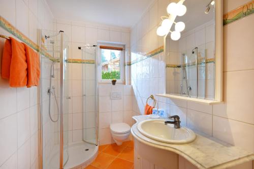 ein Bad mit einem Waschbecken, einer Dusche und einem WC in der Unterkunft Appartement Horngacher in Scheffau am Wilden Kaiser