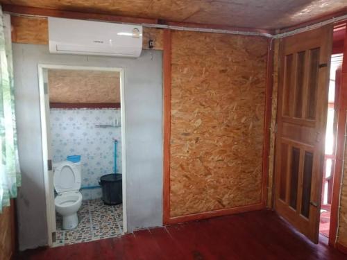 a small bathroom with a toilet and a door at Green moon Home stay room2 in Buriram