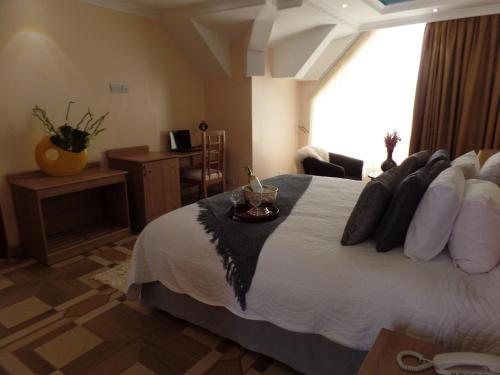 a bedroom with a large bed with pillows at Villa Leone Boutique Hotel in Nairobi
