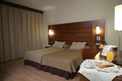 a hotel room with a bed and a table with a table sidx sidx at BS Capitulaciones in Santa Fe