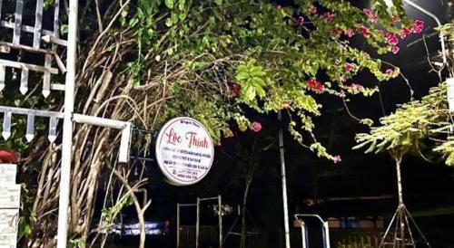a sign on the side of a building with flowers at Loc Thinh Motel in Ly Son