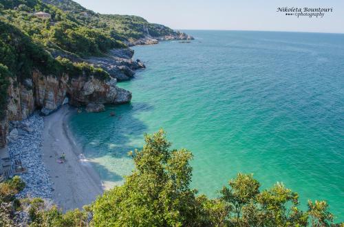 a view of a beach with people in the water at Nikolaou House in Tsagarada