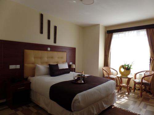 a bedroom with a bed and a table and chairs at Villa Leone Boutique Hotel in Nairobi