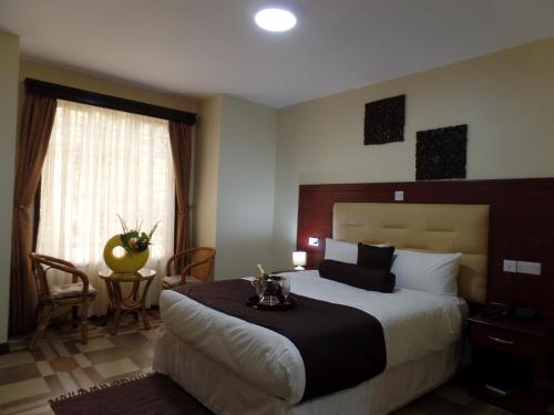 a hotel room with a large bed and a table at Villa Leone Boutique Hotel in Nairobi
