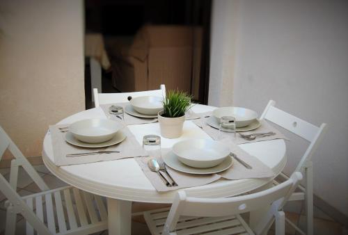 une table blanche avec de la vaisselle et une plante sur elle dans l'établissement Casa Rebella, à Marsala