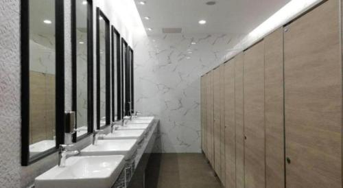 a row of sinks in a bathroom with mirrors at Royal Diamond Hotel in Phetchaburi