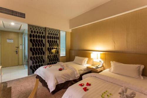 - une chambre d'hôtel avec 2 lits fleuris dans l'établissement Jinjiang Metropolo Hotel - Langfang Wanda Plaza, à Langfang