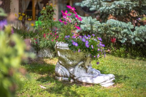 a stone planter with flowers in a garden at Hotel Romantica in Zermatt