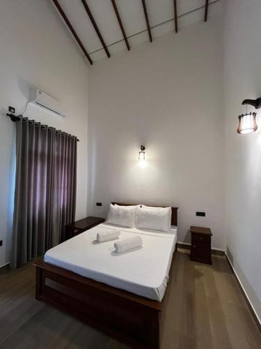 a bedroom with a bed with two towels on it at Cashew Garden Resort & Restaurant in Dambulla