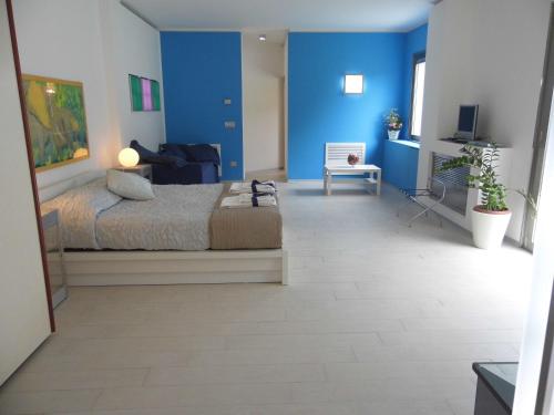 サンタ・ヴェネリーナにあるFiore dell'Etnaの青い壁のベッドルーム1室(ベッド1台付)
