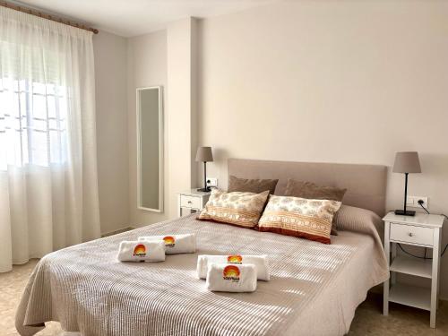 a white bedroom with a bed with towels on it at Apartamento Adelfa By Solymar Holiday in Benajarafe