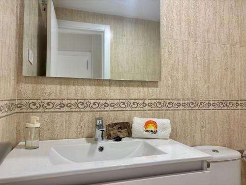 a bathroom with a sink and a mirror and a toilet at Apartamento Adelfa By Solymar Holiday in Benajarafe