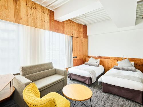 a hotel room with two beds and a couch at ONE@Tokyo in Tokyo