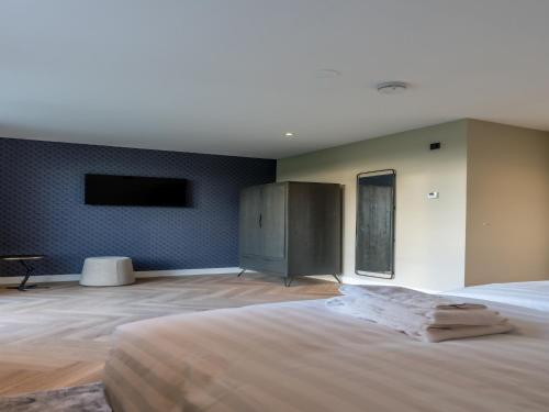 une chambre avec un grand lit et une télévision à écran plat dans l'établissement Modern villa in De Cocksdorp near the beach, à De Cocksdorp