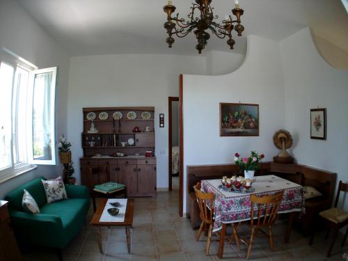 ein Wohnzimmer mit einem Tisch und einer grünen Couch in der Unterkunft Villa Maria in Conversano