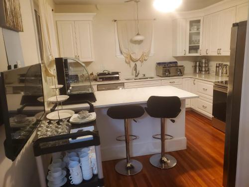 een keuken met 2 barkrukken en een aanrecht bij Casino near in Malden