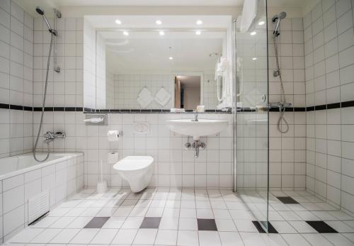 a bathroom with a sink and a toilet and a shower at Hotell Bondeheimen in Oslo