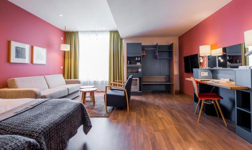 a bedroom with a bed and a living room at Hotell Bondeheimen in Oslo