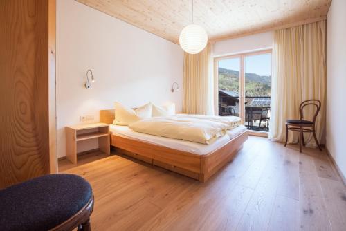 um quarto com uma cama e uma grande janela em AlpenApart Montafon - Appartement Sennerei em Schruns