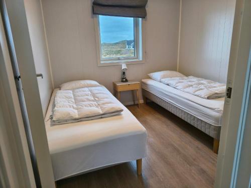 deux lits dans une petite pièce avec une fenêtre dans l'établissement 6 person holiday home in Dyrvik, à Dyrvik