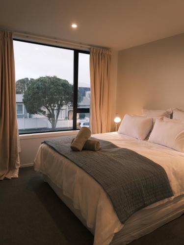 a bedroom with a large bed with a large window at The Petone Beauty - Flash, Beachside in Lower Hutt