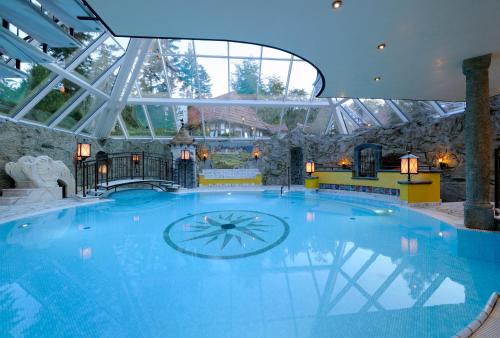 duży basen w budynku ze szklanym sufitem w obiekcie VILA VITA Burghotel Dinklage w mieście Dinklage
