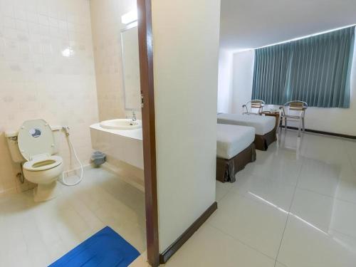 a bathroom with two beds and a toilet and a sink at Lake Inn Hotel in Songkhla