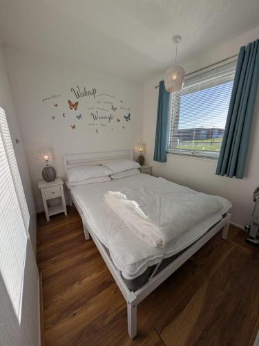 a bedroom with a bed and a window at 159, Two bed Chalet on Sunbeach Holiday Park - Sleeps 5, pet friendly - Onsite entertainment, SWIMMING PASSES INCLUDED - plus WiFi, bed linen and towels included - only 300m from the beach! in Scratby
