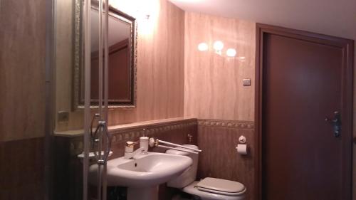 a bathroom with a sink and a toilet and a mirror at Villa Podkowa in Podkowa Leśna