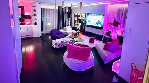 Una sala de estar con muebles rosas y un televisor. en BEAUTIFUL PLACE WITH BREATHTAKING PRIVATE ROOFTOP TERRACE 210m2 IN CITY OF LOVE PARIS, en París