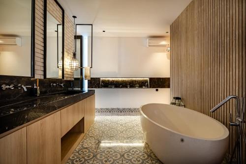 een badkamer met een groot bad en een wastafel bij Villa Zeno Arete Pererenan 6 Bedroom , Ice Bath, Sauna and Gym in Tumbak Bayuh