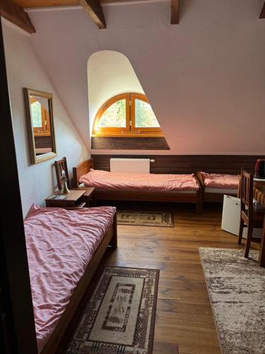 a room with two beds and a window at Dworek Mieldziczowka in Supraśl