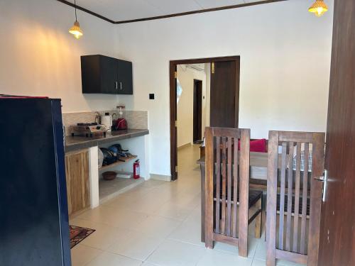 a kitchen with a table and two wooden chairs at MJ Villa Ahangama in Ahangama