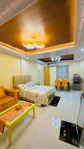 a bedroom with a bed and a couch and a table at CEEJ Building Transient Studio Rooms in Iloilo City