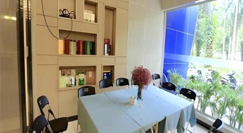 une pièce avec une table et des chaises et une grande fenêtre dans l'établissement Echarm Hotel Nanning Nationalities Square Metro Station, à Nanning