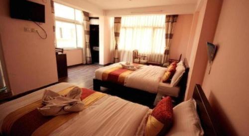 a hotel room with two beds and a television at De Hotel Veda in Kathmandu
