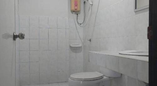 une salle de bain blanche avec toilettes et lavabo dans l'établissement Chill Beach Resort, à Pathiu