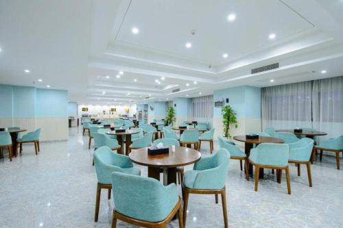une salle d'attente avec des tables et des chaises dans un bâtiment dans l'établissement Guilin Manhatton Hotel Tianjie, à Guilin