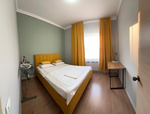 Un dormitorio pequeño con una cama y una ventana. en Уютная и комфортная 3х комнатная в новом центре, en Uralsk