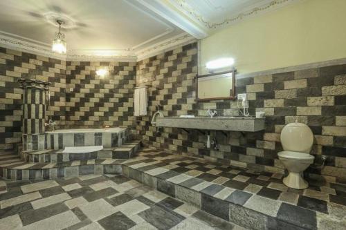 une salle de bain avec un lavabo, des toilettes et une baignoire dans l'établissement Grand Norling Hotel's Resort, à Baudhatinchule