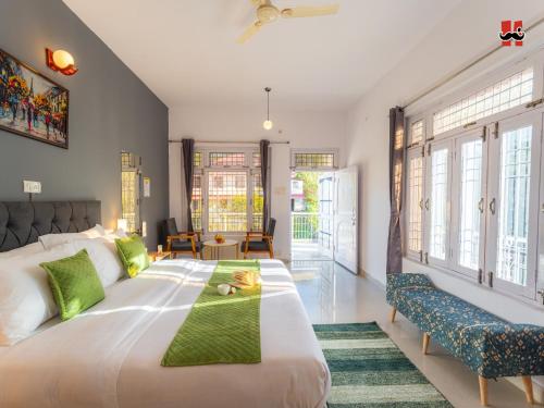 a bedroom with a large white bed with green pillows at Moustache Bir in Bīr