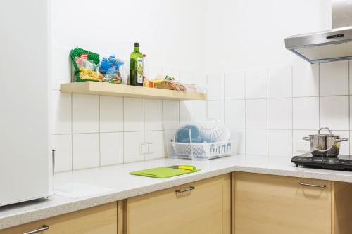 a kitchen with white tiled walls and wooden cabinets at a&o Salzburg Hauptbahnhof in Salzburg