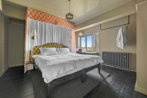 a bedroom with a bed with an orange wall at Finest Retreats - ARC Thorpeness in Thorpeness