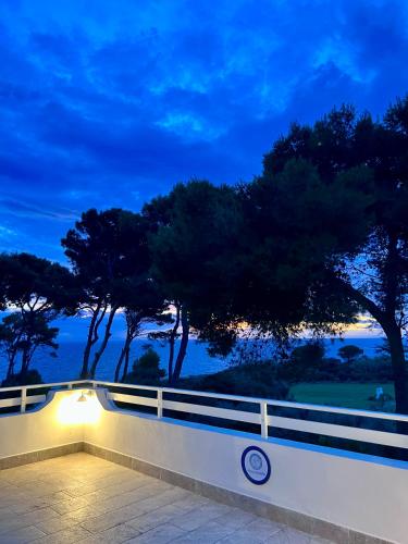 a light on a fence with trees in the background at Villa Calipso in Taranto