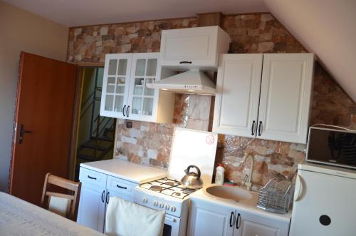 a kitchen with white cabinets and a sink at Noclegi u Banysia w sercu Gór Świętokrzyskich in Krajno Pierwsze