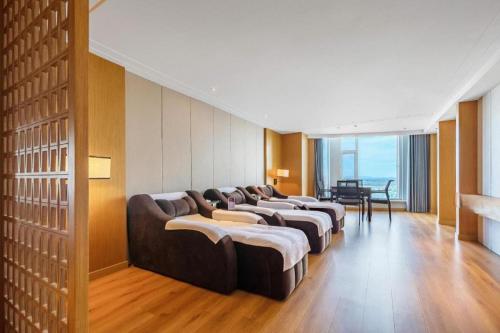 Una fila de sofás están alineados en una habitación. en Dandong Xin An Dong Hotel, en Dandong