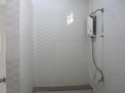 a shower in a white bathroom with a shower at The Palm Village in Ban Non Chan